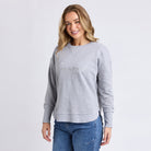 Woman wearing a gray sweatshirt with a logo on a white background